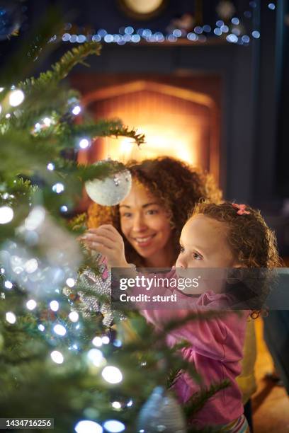 den weihnachtsbaum anziehen - kids dressing up stock-fotos und bilder