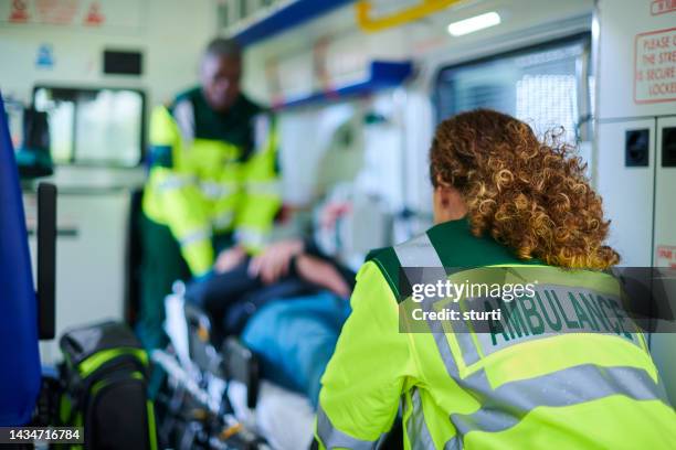 krankenwagenbesatzung bereitet verwundete vor - rettung stock-fotos und bilder