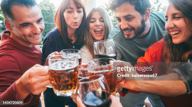 group of friends toasting beer and wine glasses together - beer goggles stock pictures, royalty-free photos & images