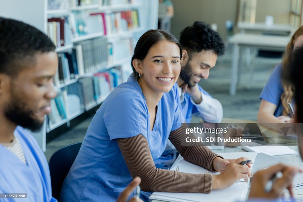 Fellow students smile as two classmates discuss ideas