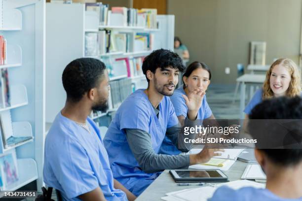 diverse medical students enjoy discussion while studying - learn arabic stockfoto's en -beelden