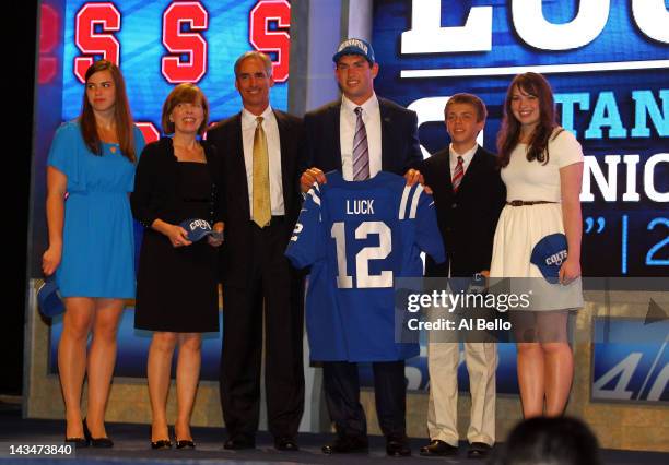 Andrew Luck, #1 overall pick by the Indianapolis Colts out of Stanford, holds up a Colts jersey as he poses on stage with his father Oliver, mother...