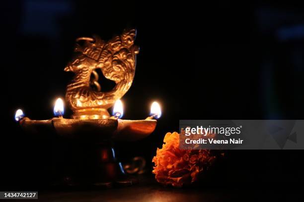 lit oil peacock brass lamp and marigold flower- deepavali/diwali festival/india - diya oil lamp stockfoto's en -beelden