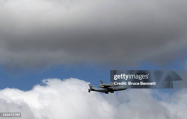 Riding atop a 747 shuttle carrier aircraft, the space shuttle Enterprise flies over New York Harbor on April 27, 2012 in New York City. Enterprise,...