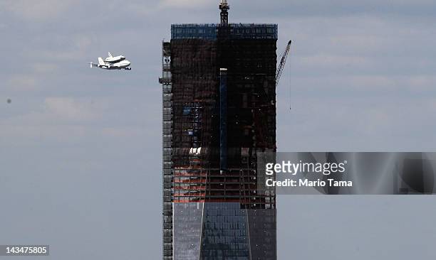 Space shuttle Enterprise, mounted atop a 747 shuttle carrier aircraft, flies past One World Trade Center prior to landing at John F. Kennedy...
