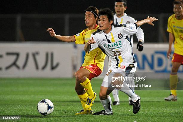 Tatsushi Koyanagi of Thespa Kusatsu and Tomoki Ikemoto of Giravanz Kitakyushu compete for the ball during the J.League Second Division match between...