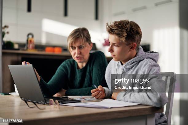 madre ayudando al hijo con algunas tareas - homework fotografías e imágenes de stock