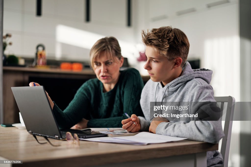 Une mère aide son fils à faire ses devoirs