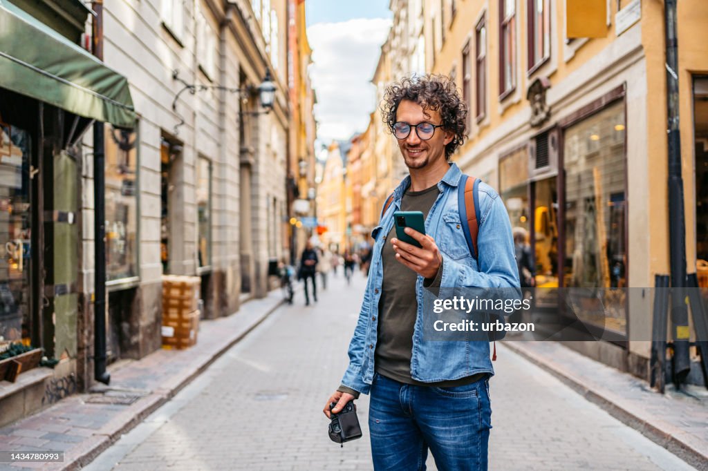 Junger Tourist mit einer Karte auf einem Smartphone
