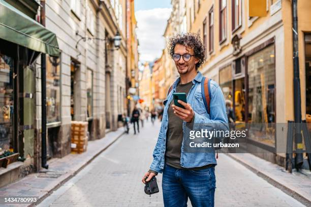 young tourist using a map on a smart phone - explorer 個照片及圖片檔
