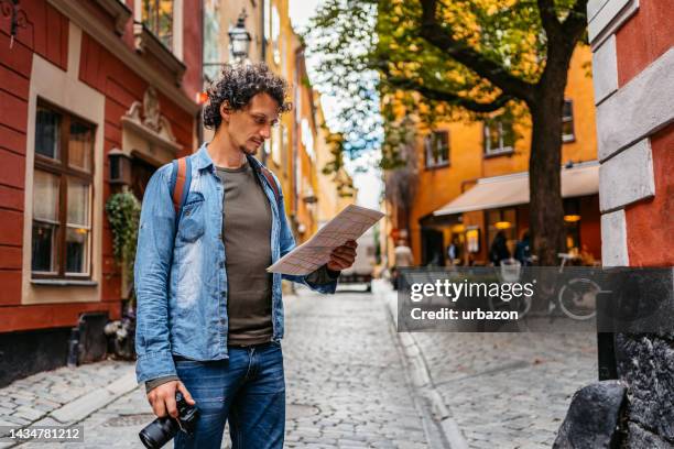 young tourist reading a map in the city - stockholm map stock pictures, royalty-free photos & images