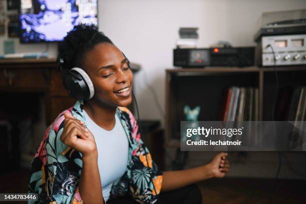 young woman listening to music at home - retro futurism space stock pictures, royalty-free photos & images