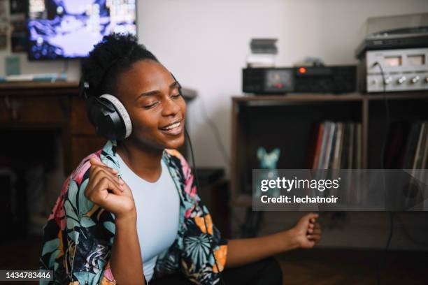 young woman listening to music at home - vintage stereo stock pictures, royalty-free photos & images