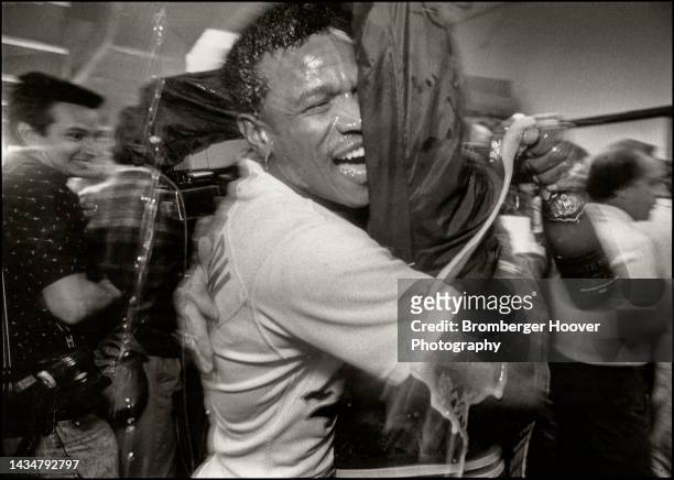 View of American baseball player Rickey Henderson, of the Oakland A's, in the locker room as he celebrates his team's victory in the American League...