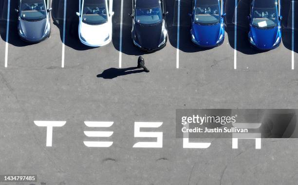 In an aerial view, brand new Tesla cars sit in a parking lot at the Tesla factory on October 19, 2022 in Fremont, California. Electric car maker...