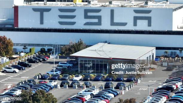 In an aerial view, brand new Tesla cars sit in a parking lot at the Tesla factory on October 19, 2022 in Fremont, California. Electric car maker...