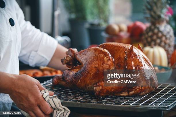 preparing stuffed turkey for holidays in domestic kitchen - fylld kalkon bildbanksfoton och bilder
