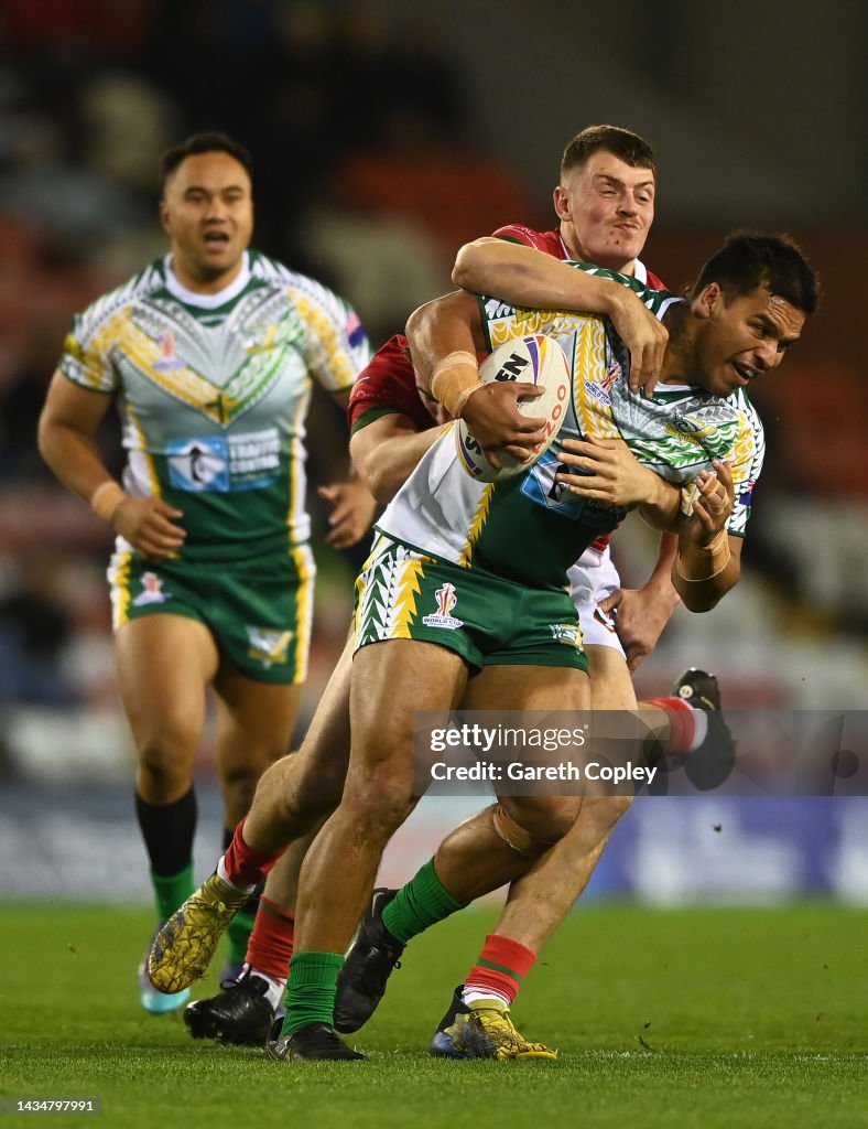 Bruce Cook Rugby Pride Petterson-Robati of Cook Islands is tackled by Will Evans of ...