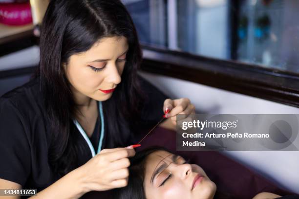 stylist performing thread eyebrow design - tweezing eyebrows stock pictures, royalty-free photos & images