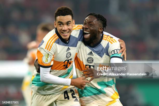 Jamal Musiala of Bayern Munich celebrates scoring their side's fourth goal with teammate Alphonso Davies during the DFB Cup second round match...