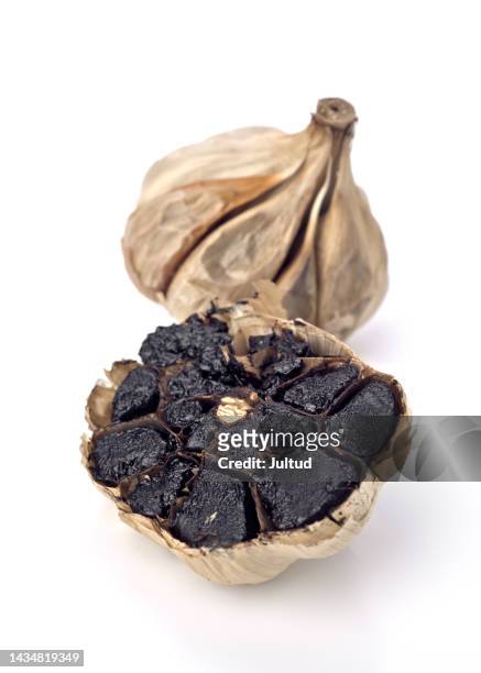 close-up shot of cut black garlic head, isolated on white background - knoblauch stock-fotos und bilder