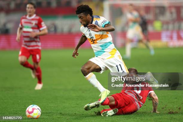 Kingsley Coman of Bayern Munich is challenged by Mads Pedersen of FC Augsburg during the DFB Cup second round match between FC Augsburg and FC Bayern...