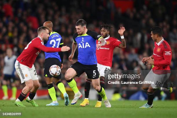 Pierre-Emile Hojbjerg of Tottenham Hotspur is challenged by Fred and Luke Shaw of Manchester United during the Premier League match between...