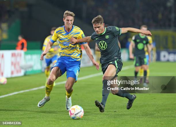 Micky van de Ven of VfL Wolfsburg is challenged by Lion Lauberbach of Eintracht Braunschweig during the DFB Cup second round match between Eintracht...