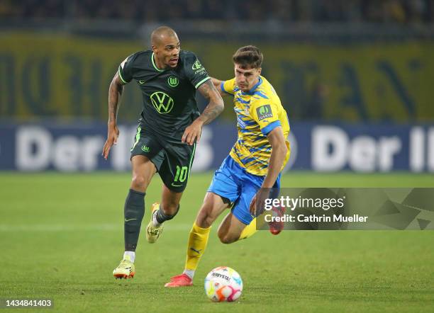 Lukas Nmecha of VfL Wolfsburg is challenged by Danilo Wiebe of Eintracht Braunschweig during the DFB Cup second round match between Eintracht...