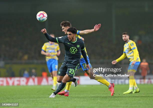 Omar Marmoush of VfL Wolfsburg is challenged by Danilo Wiebe of Eintracht Braunschweig during the DFB Cup second round match between Eintracht...