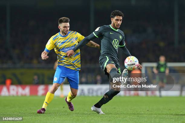 Omar Marmoush of VfL Wolfsburg is challenged by Maurice Multhaup of Eintracht Braunschweig during the DFB Cup second round match between Eintracht...