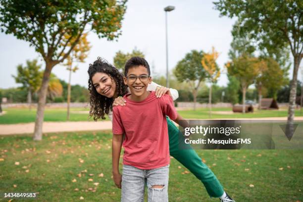 children playing shoulder carry - hispanic boy and girl stock pictures, royalty-free photos & images