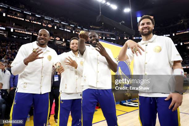 Andre Iguodala, Stephen Curry, Draymond Green, and Klay Thompson of the Golden State Warriors pose with their championship rings in front of a...