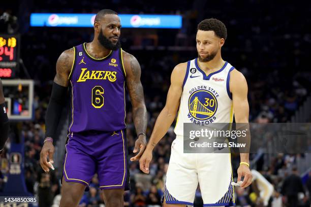 LeBron James of the Los Angeles Lakers speaks to Stephen Curry of the Golden State Warriors during their game at Chase Center on October 18, 2022 in...