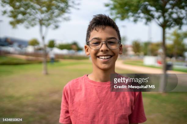 公共の広場で笑う少年の肖像画 - skinny teen ストックフォトと画像