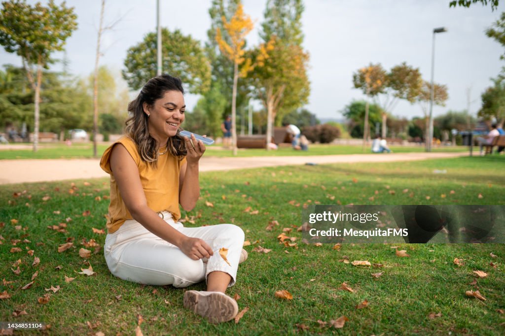 Une femme envoie un message vocal sur la place publique
