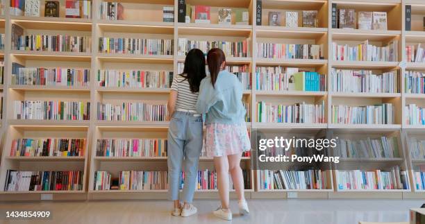 asiatische mädchen finden bücher - buchhandlung stock-fotos und bilder
