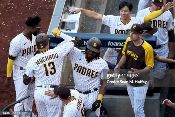 Manny Machado of the San Diego Padres celebrates with Josh Bell after hitting a solo home run during the seventh inning against the Philadelphia...