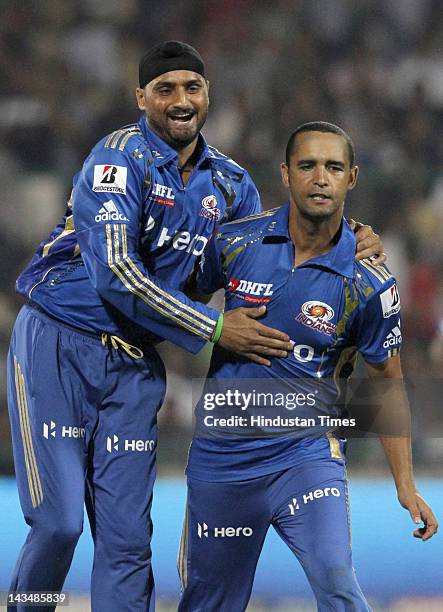 Mumbai Indians captain Harbhajan Singh celebrates with teammate Robin Peterson after the dismissal of Delhi Daredevils batsman Virender Sehwag during...