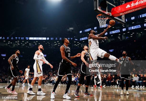 Zion Williamson of the New Orleans Pelicans goes to the basket as Nic Claxton and Ben Simmons of the Brooklyn Nets defend during the first half at...