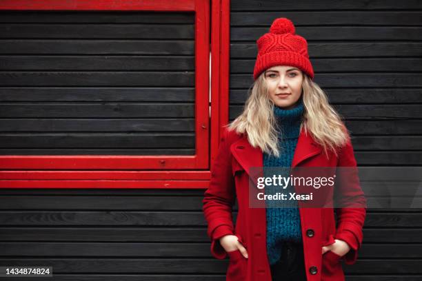 porträt einer schönen frau in roter jacke im winter - roter mantel stock-fotos und bilder