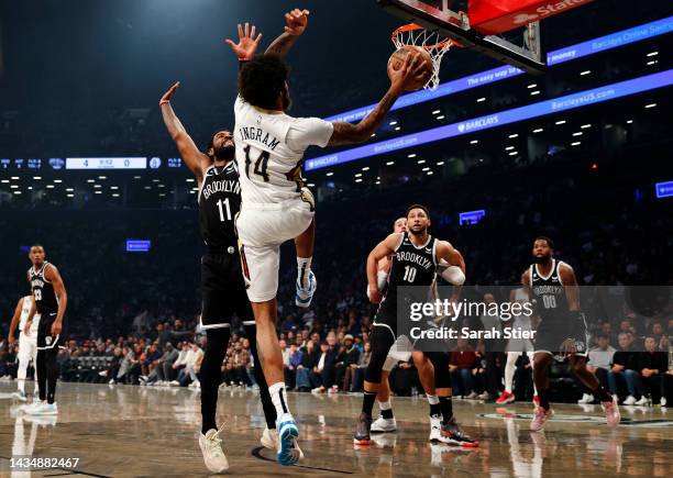 Brandon Ingram of the New Orleans Pelicans looks to pass as Kyrie Irving of the Brooklyn Nets defends during the first half against the Brooklyn Nets...
