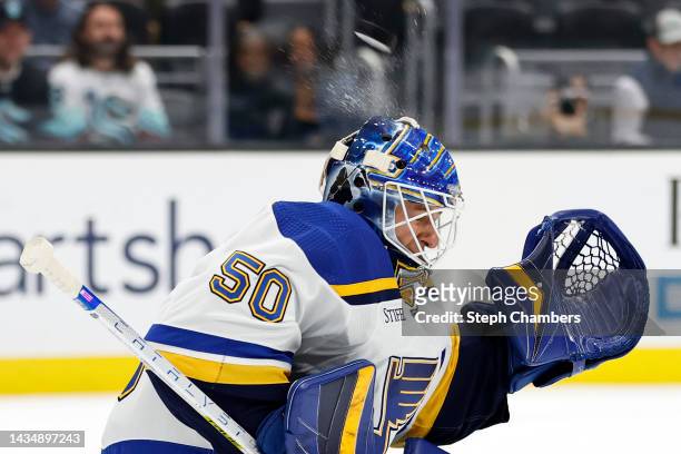 Jordan Binnington of the St. Louis Blues makes a save with his helmet during the second period against the Seattle Kraken at Climate Pledge Arena on...