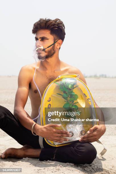 a conceptual shoot showing a man breathing oxygen from plant. - climate change health stock pictures, royalty-free photos & images