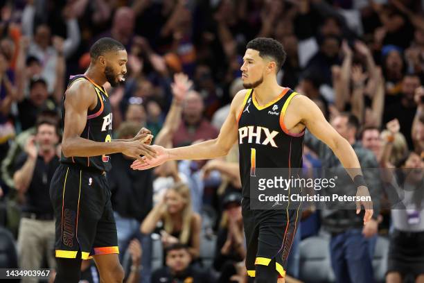 Devin Booker of the Phoenix Suns celebrates with Mikal Bridges after defeating the Dallas Mavericks the NBA game at Footprint Center on October 19,...