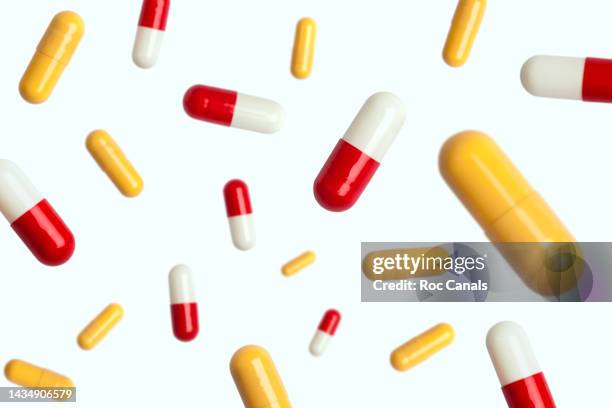 capsules in mid air - medicare supplement stock pictures, royalty-free photos & images