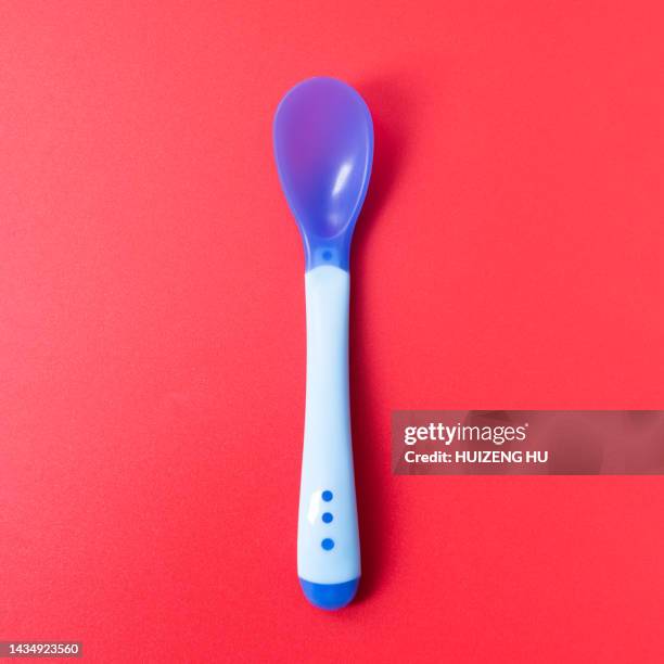 baby spoon on red background - baby spoon stock pictures, royalty-free photos & images