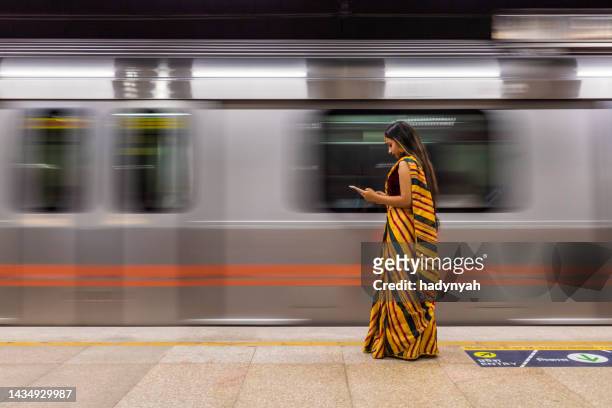 indisches mädchen mit einem digitalen tablet an der u-bahn-station, indien - india train stock-fotos und bilder