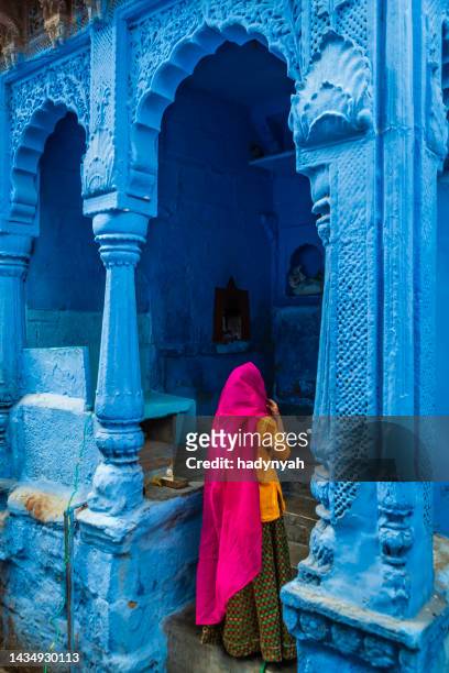 young indian woman walking inside a blue city of jodhpur, india - jodhpur imagens e fotografias de stock
