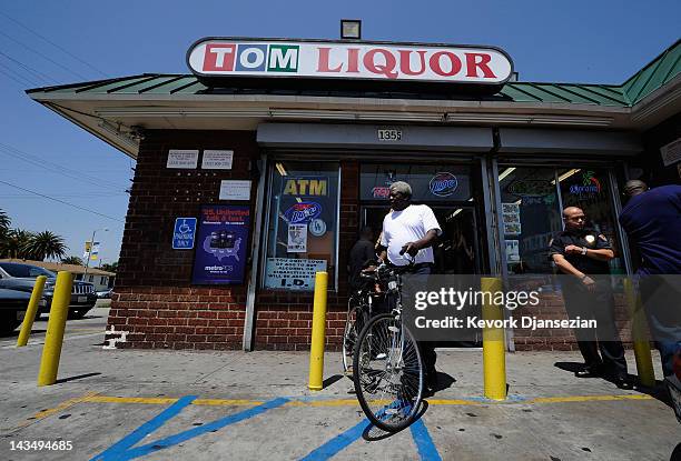 Security guard keeps watch outside Tom Liquor store at the intersection of Florence and Normandy Avenues South Los Angeles on April 27, 2012 in Los...